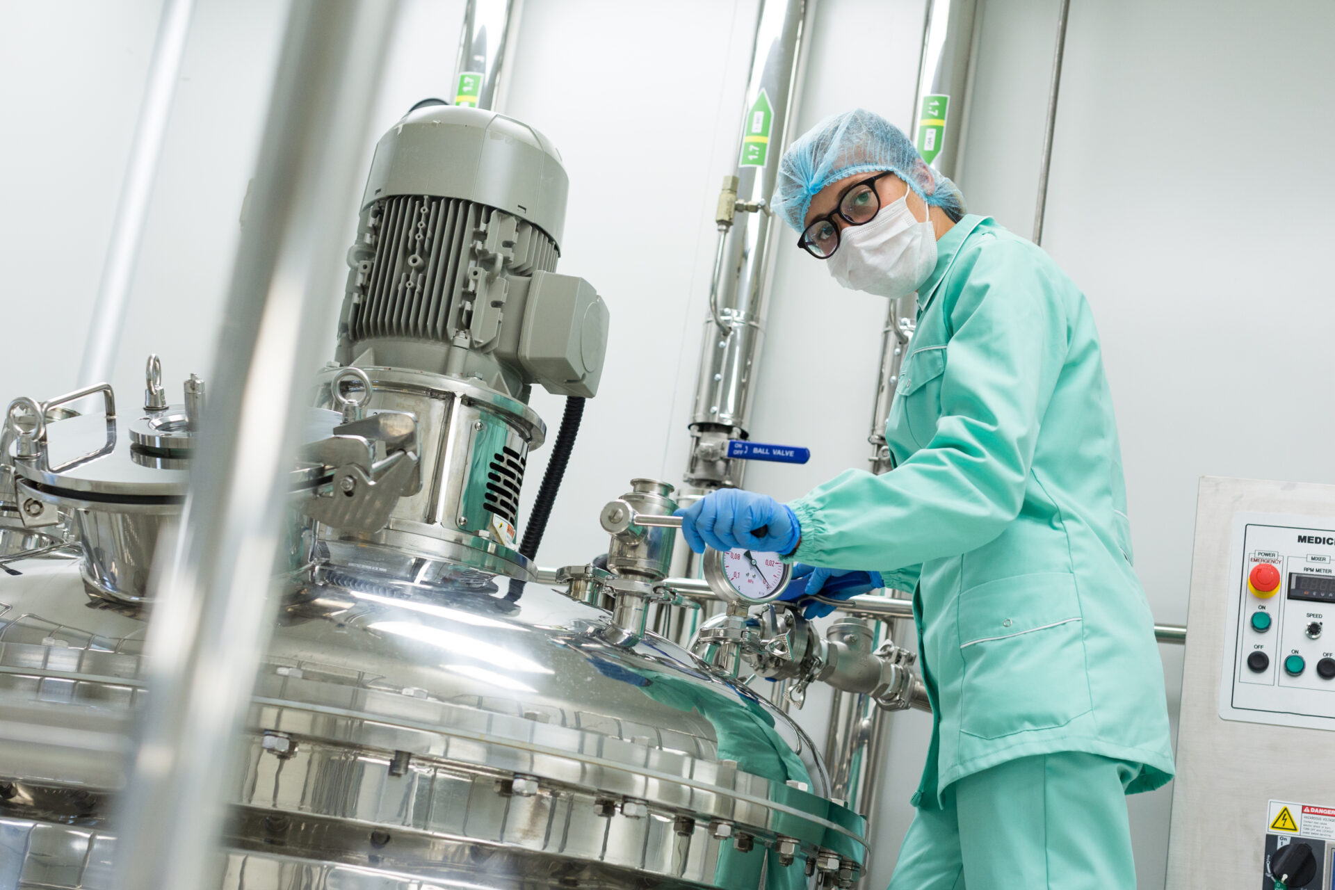 look at camera, factory worker is checking high-pressure tank